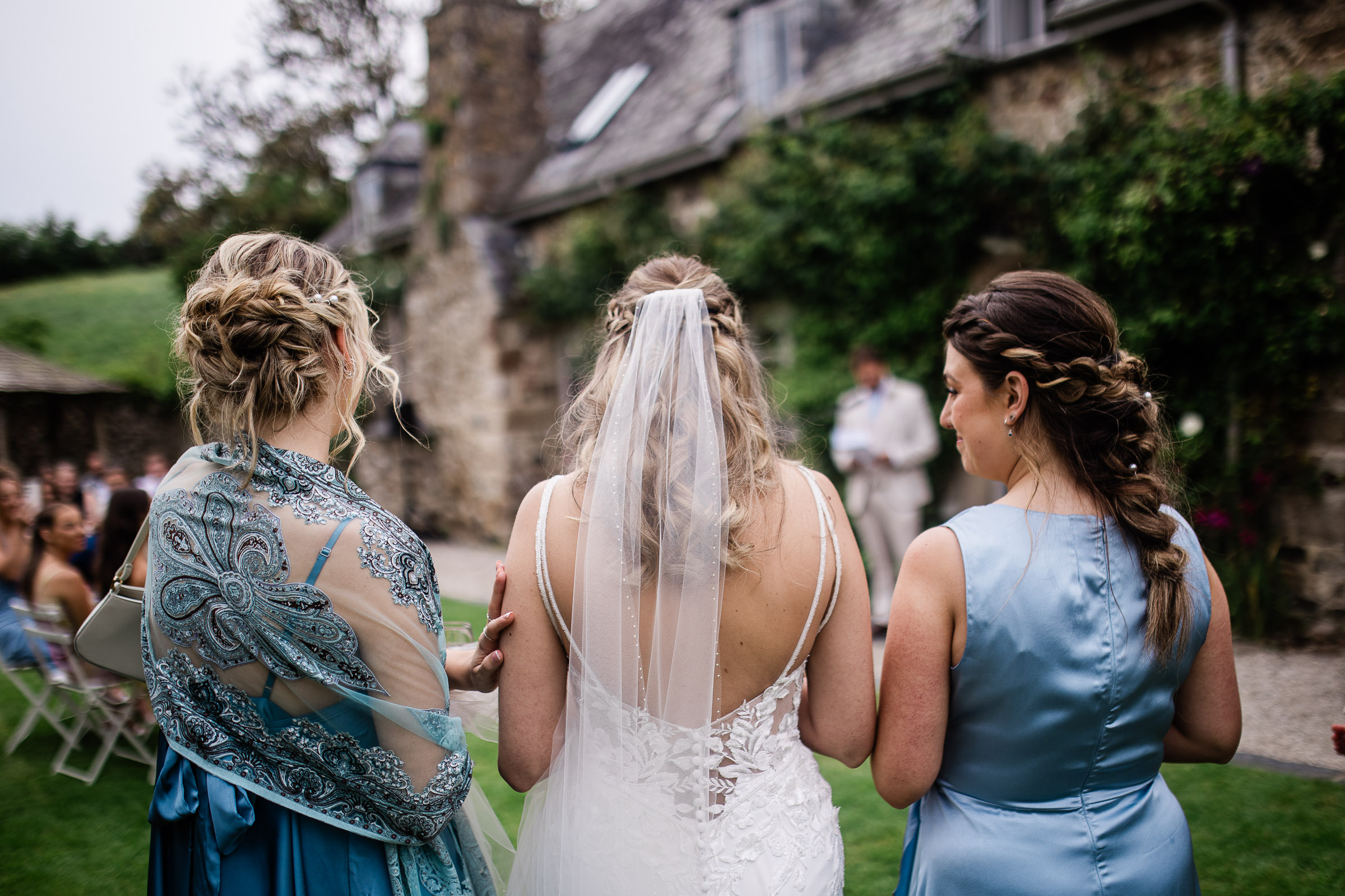 a candid moment between a bride and her bridesmaids during outdoor speeches