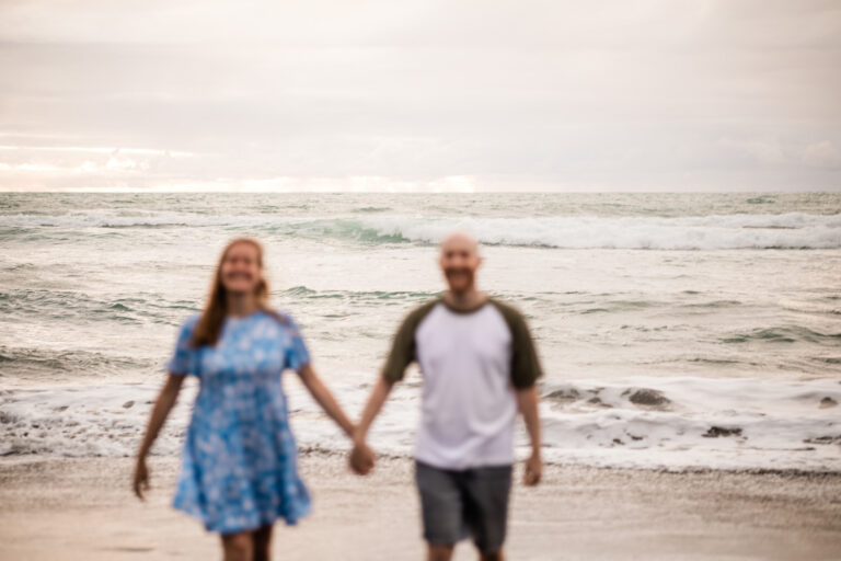 A couple walk together on a beach