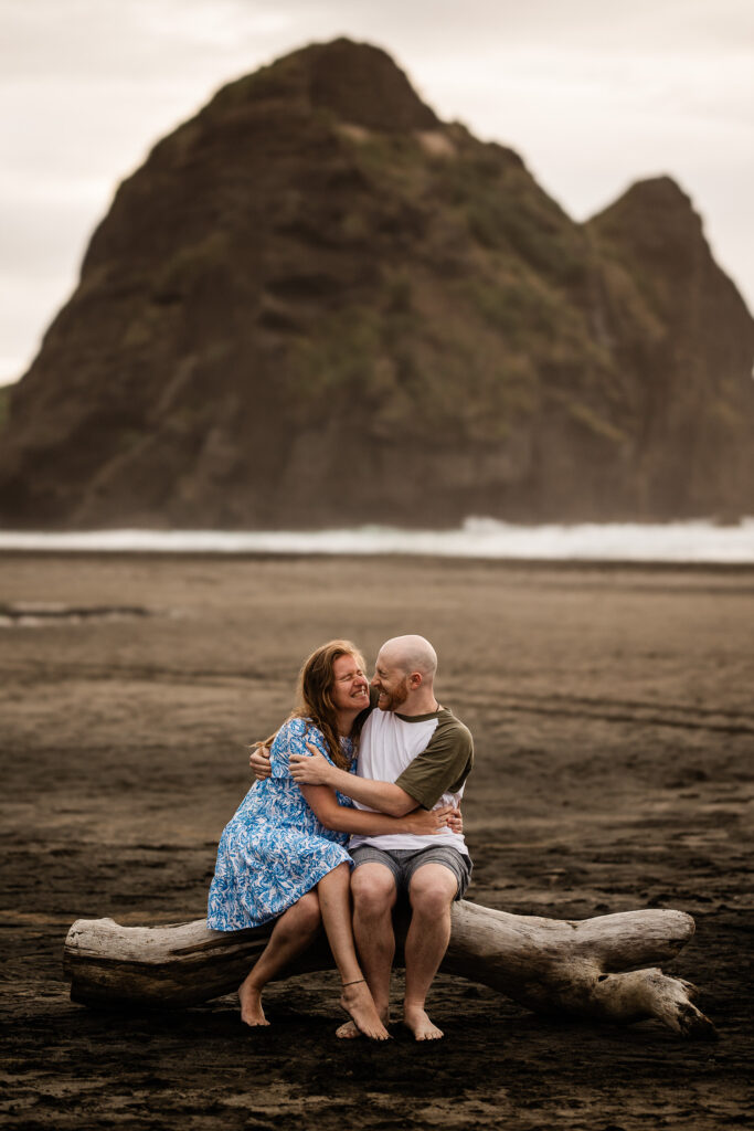 A romantic moment between a an engaged couple, on Piha beach during a documentary pre-wedding shoot