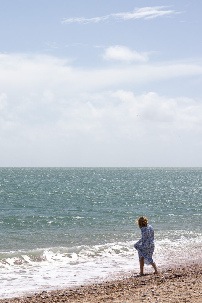 A wedding guest tests the temperature of the sea, during a wedding in the south west