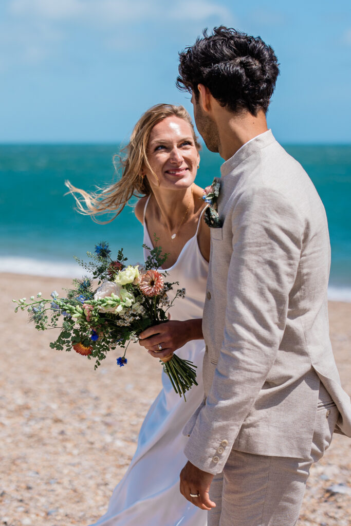 A couple smile at each other, during an outdoor wedding taken by a wedding phootgrapher in the South West