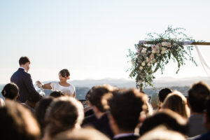 A candid moment between wedding guests during an outdoor wedding ceremony in France