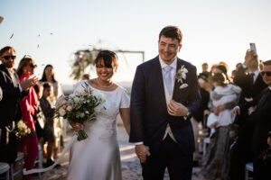 A bride and groom smile during their outdoor confetti shot at chateau cremat