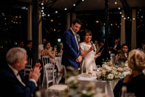 A candid moment of a bride and groom during their French and English fusion wedding speeches