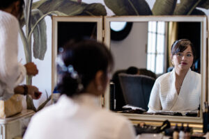 A documentary photography capture as a bride looks at herself in the mirror before her wedding day