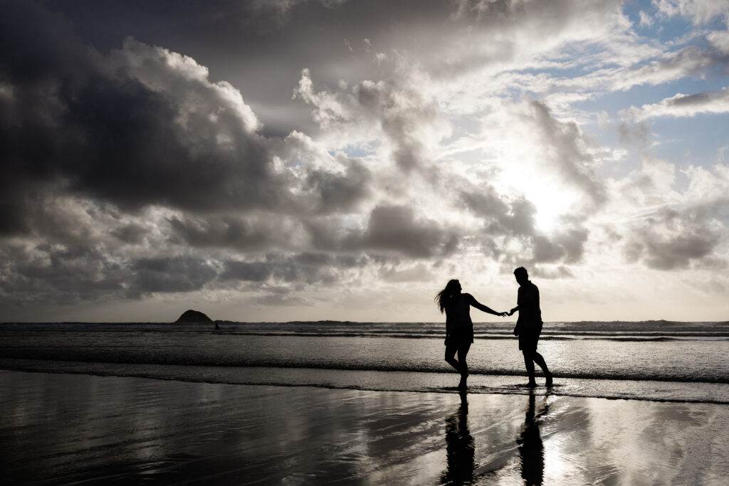 Candid destination engagement photos on a beach in New Zealand