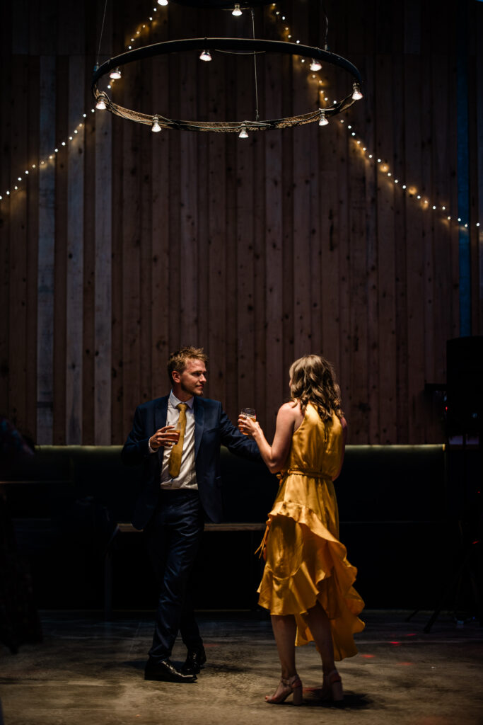 Two wedding guests dance together during a wedding reception at The Grain Store