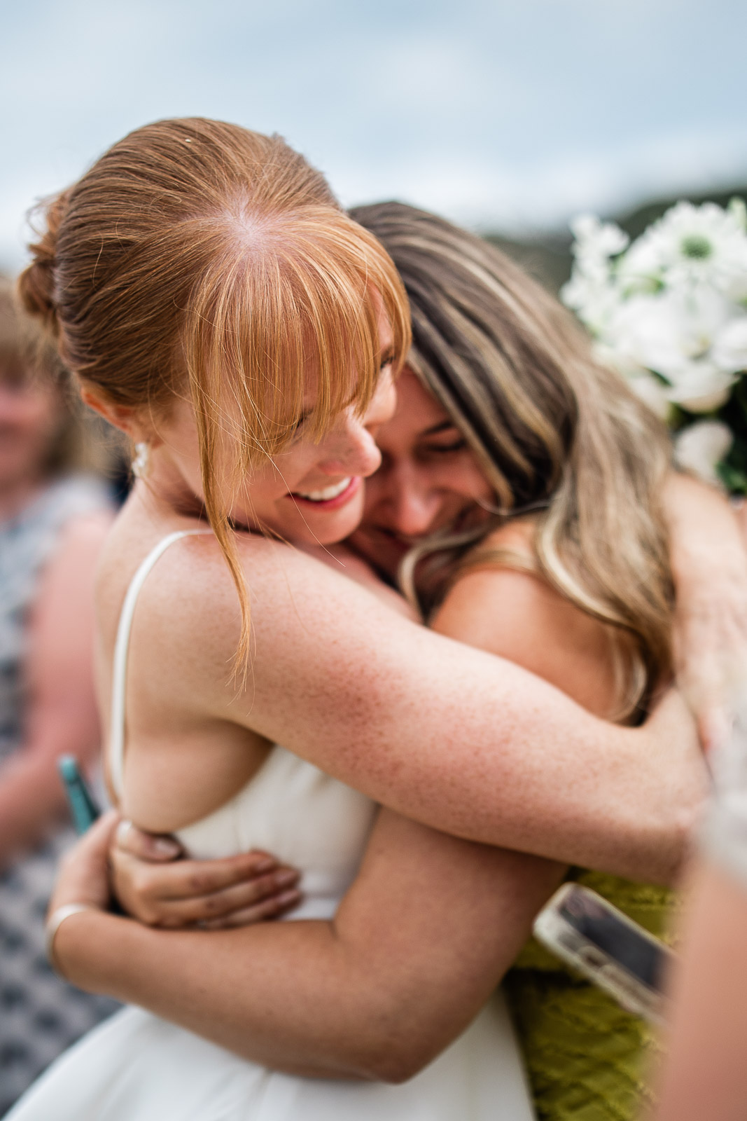 A documentary wedding photography capture as a bride and her best friend share a hug
