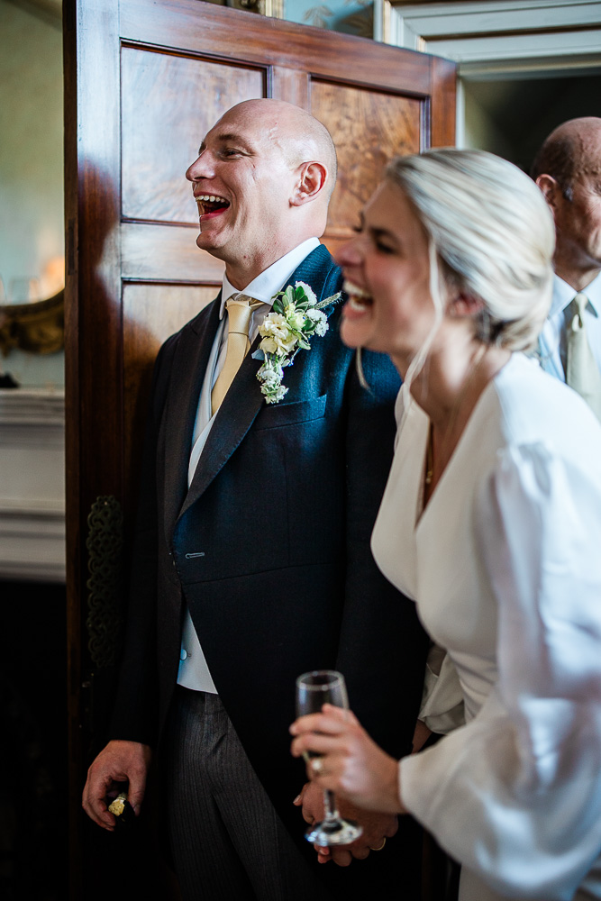 A candid moment between a bride and groom during wedding speeches at an English country house