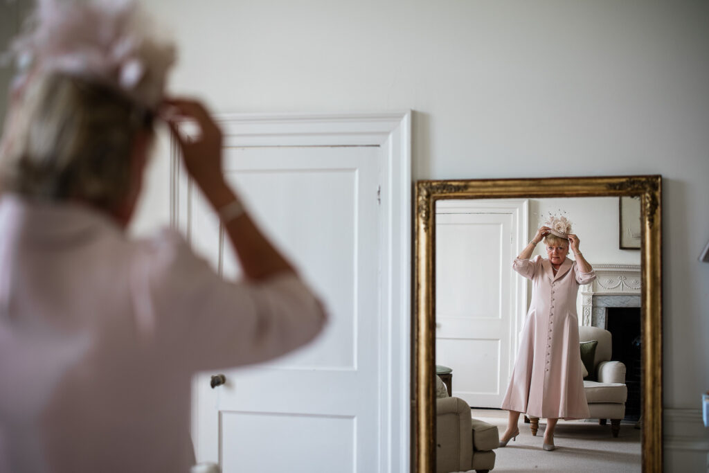 The mother of the bride adjusts her hat before the wedding ceremony
