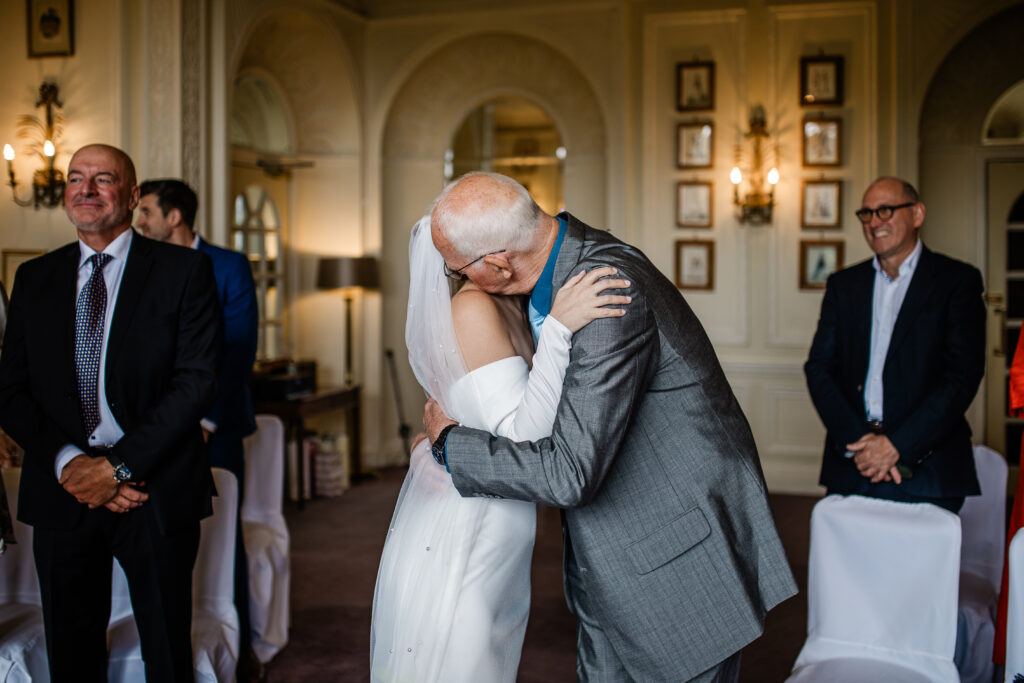 The bride hugs her father after he walks her down the aisle