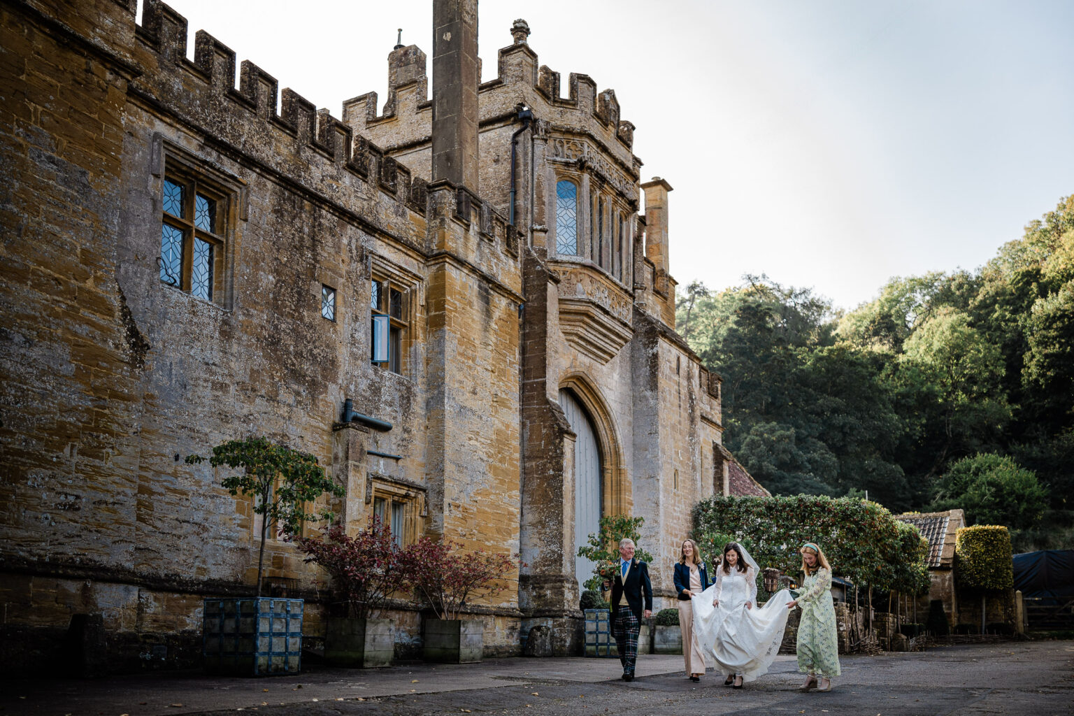 a bride walks to the wedding ceremony during a luxury castle wedding in somerset