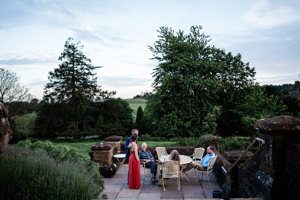 uests chat as the sun sets captured by a wedding photographer at huntsham court