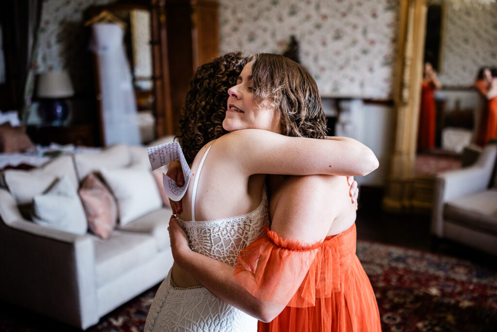wedding photographer at huntsham court capture of a bride embracing her friend