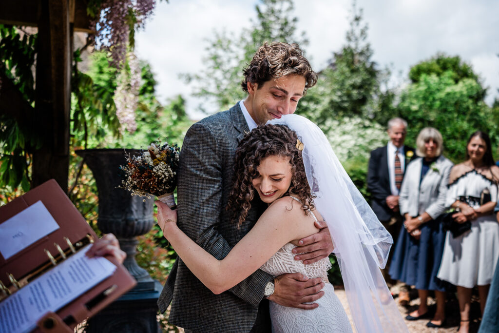 a bride and groom hug, at the start of the wedding ceremony at a manor house wedding venue