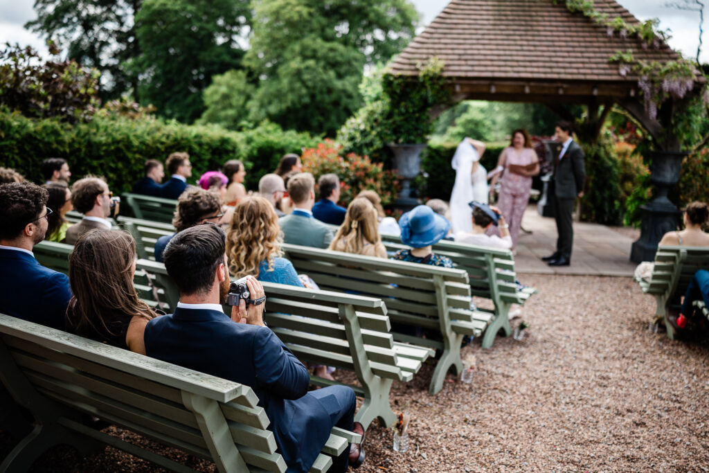 the bride and groom say their vows during an outdoor ceremony at huntsham court