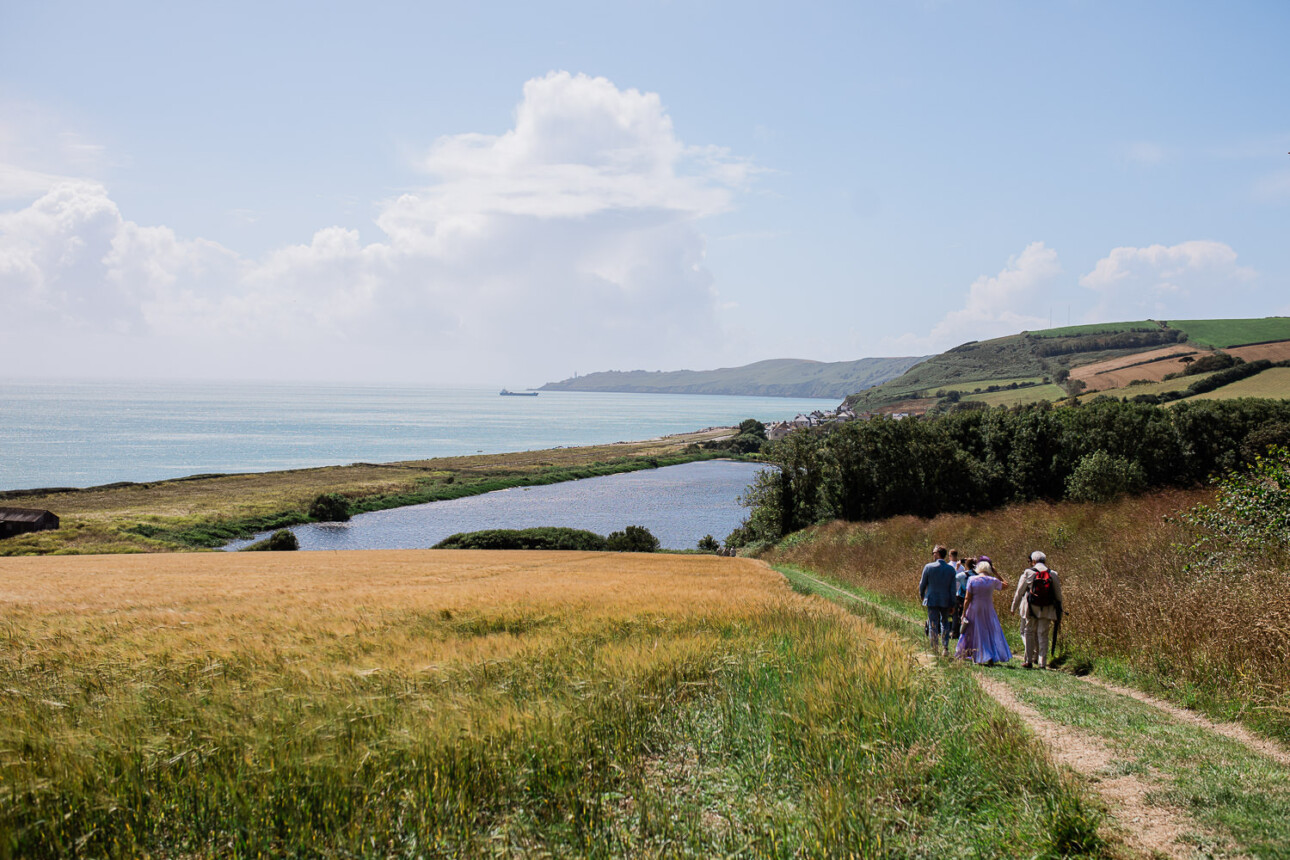 Guests on their way to an english summertime wedding ceremony by the seaside.