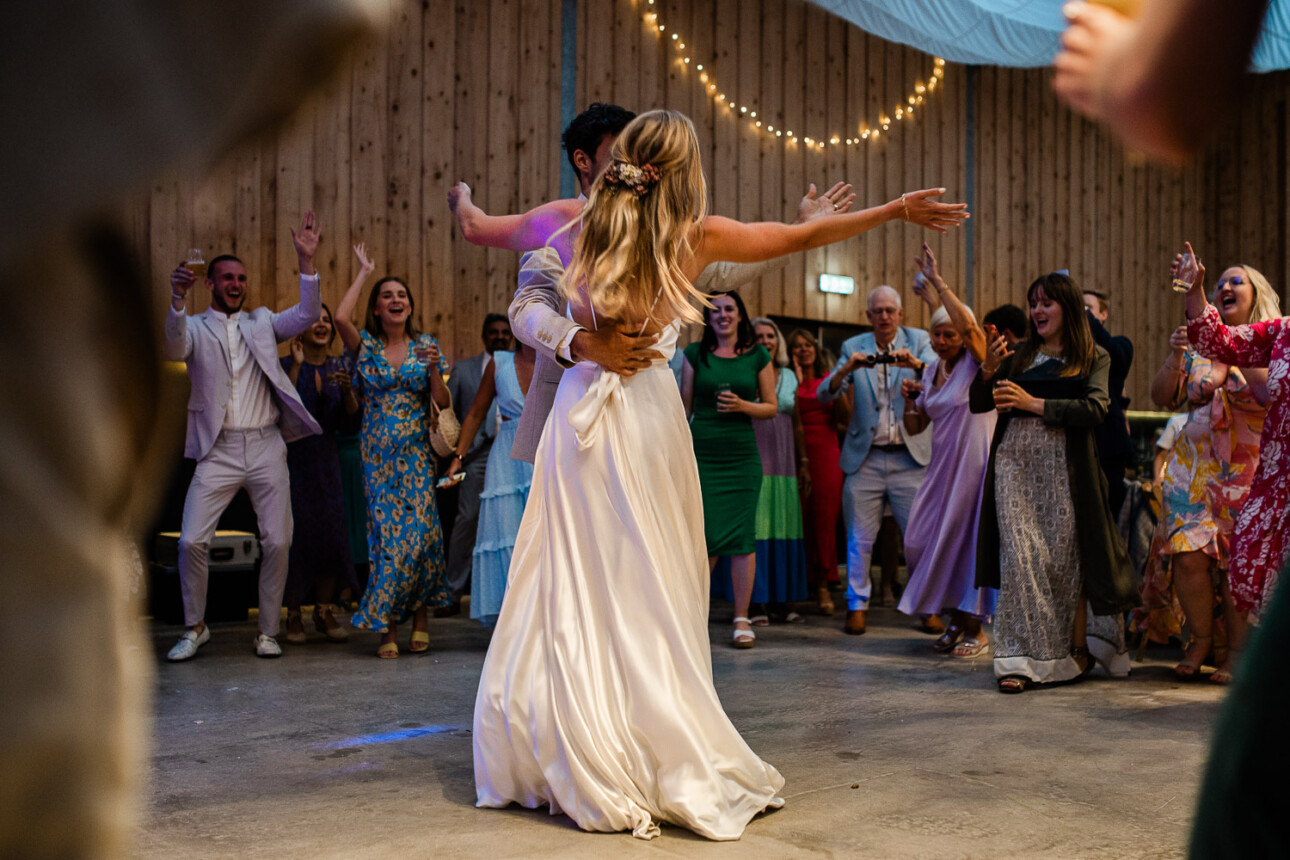 A bride and groom ask their wedding guests to join in, during the first dance at The Grain Store.