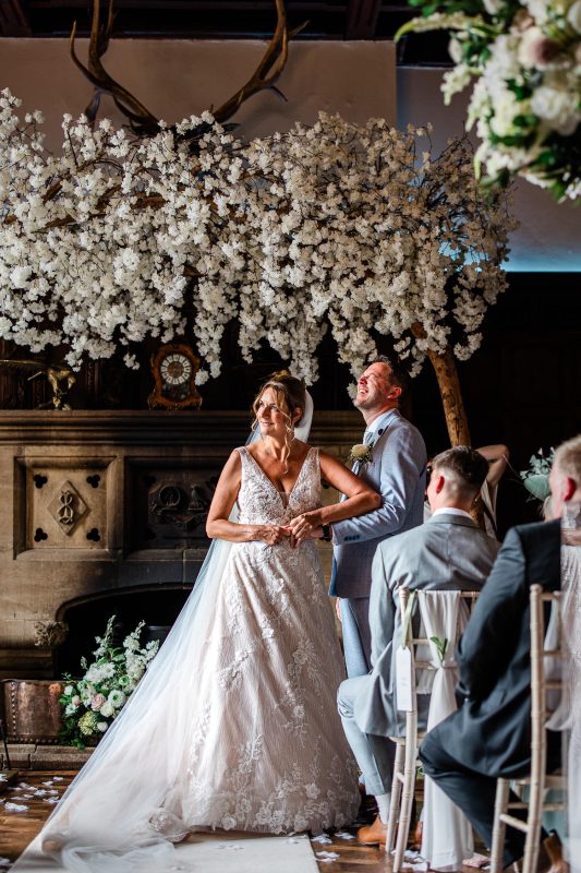 A bride laughs as she struggles to put the ring on the grooms finger, during the wedding ceremony.