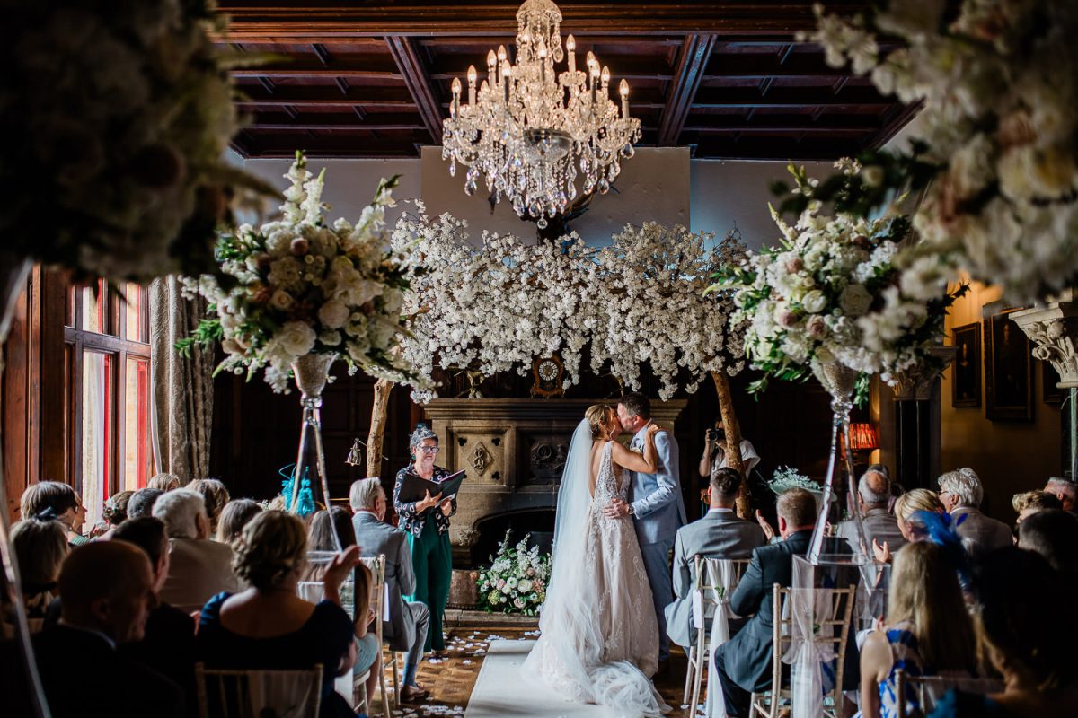 Huntsham Court wedding photography of a bride and groom exchanging their first kiss.