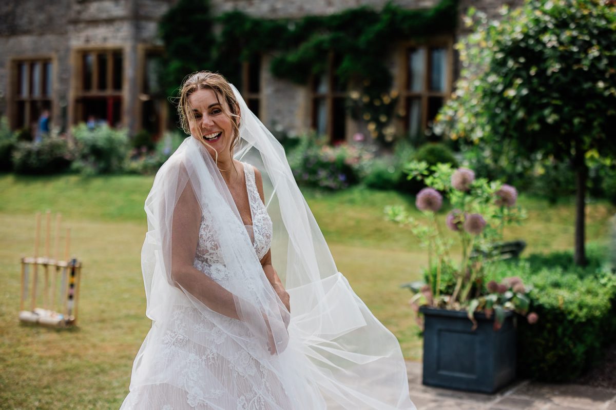 A candid capture of a bride laughing as the wind catches her veil.