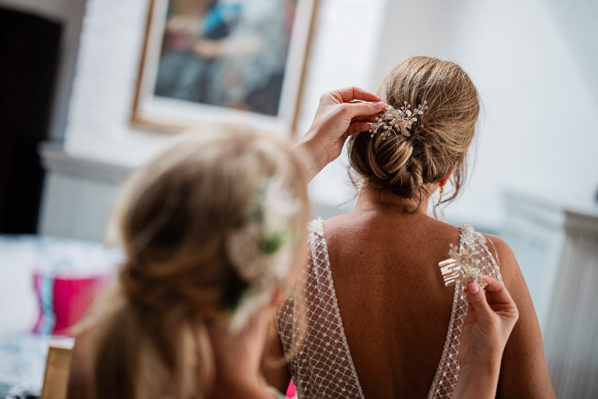A bridesmaid decides which clip to put in the brides hair.