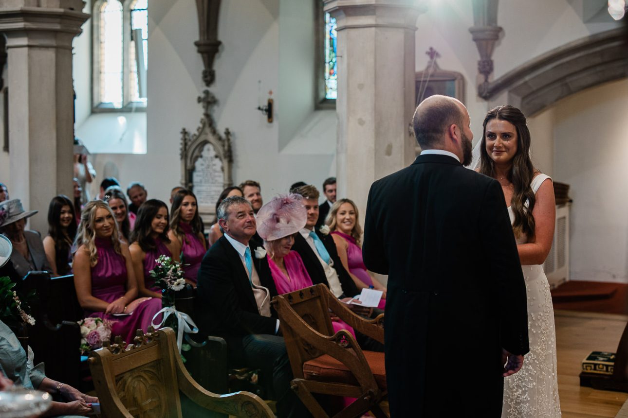 A bride and groom say their vows during a religious ceremony at a church in Sussex.