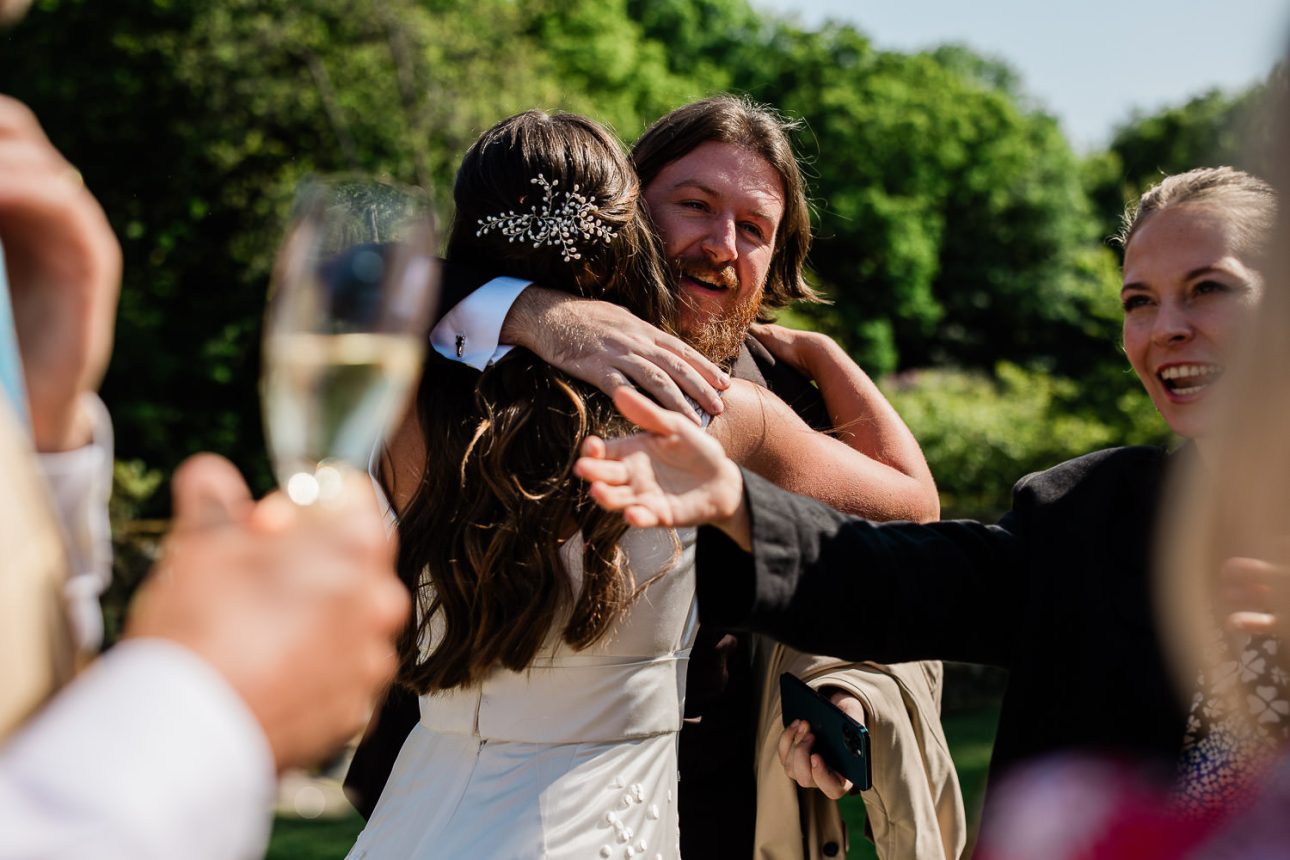 A documentary wedding photography moment where a bride embraces her friend, during the wedding reception.