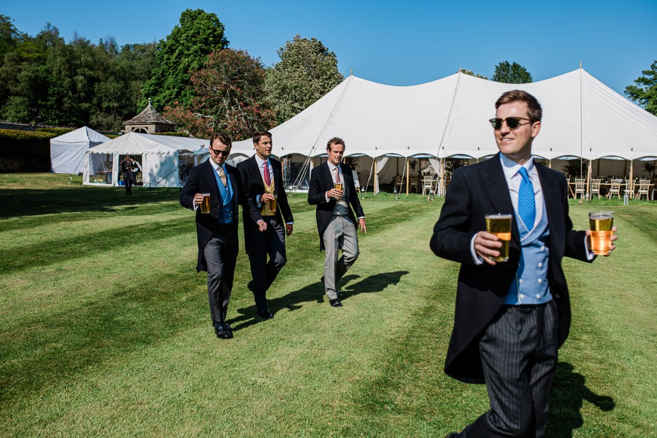 A group of groomsmen carry beers to the wedding reception.