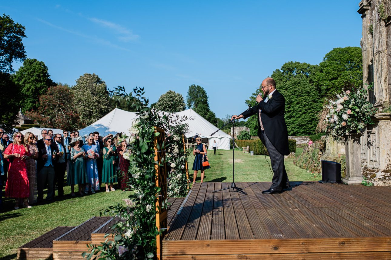 A groom makes a speech, during outdoor wedding speeches at Slaugham Place.