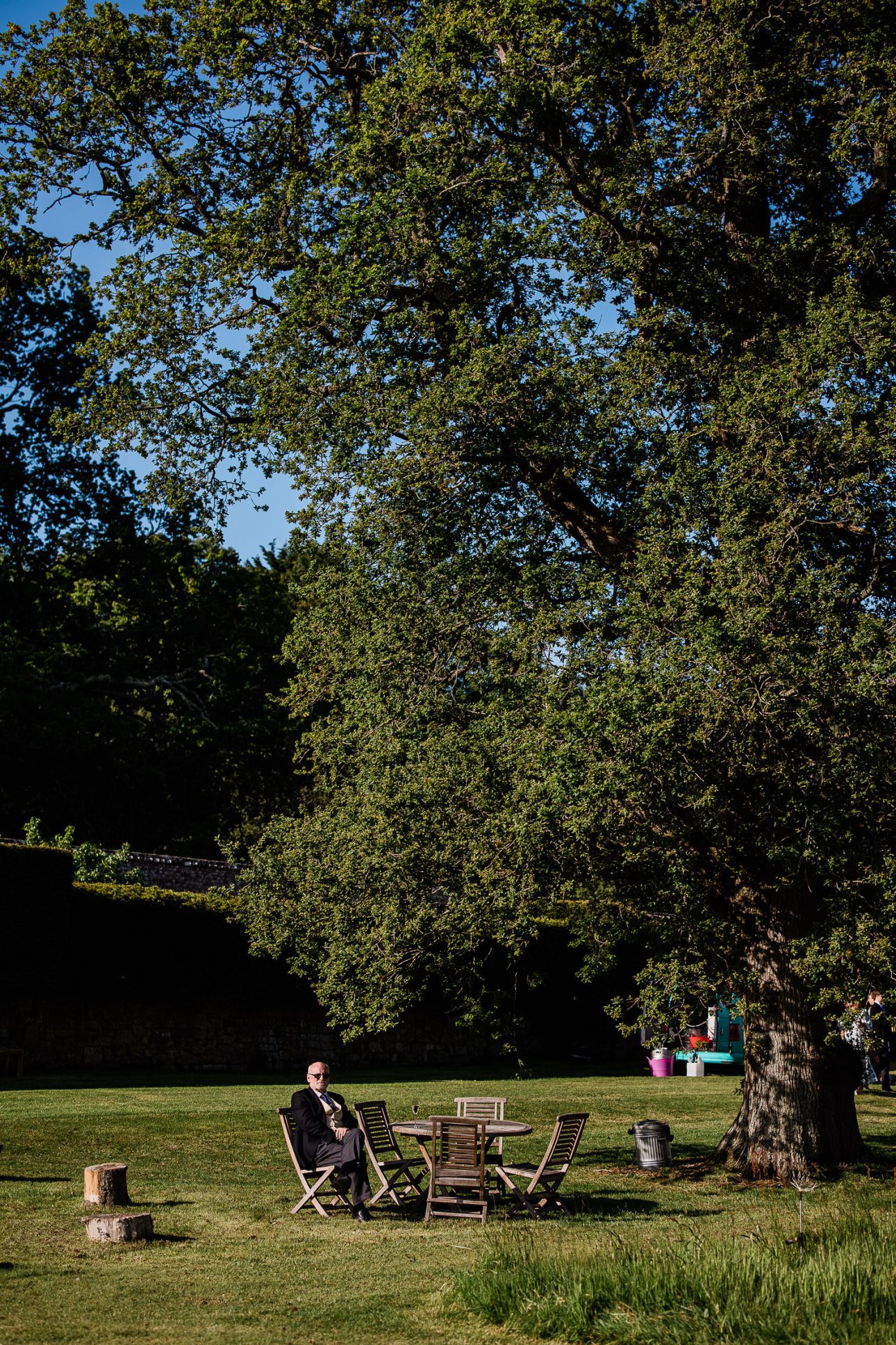 A guest relaxing at an outdoor wedding reception in an English woodland.