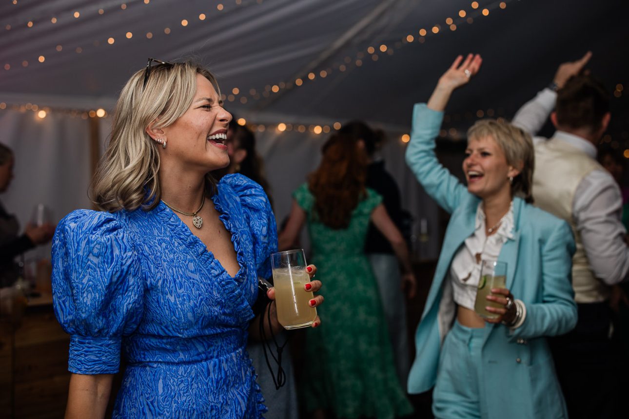 Wedding guests enjoying the music on the dance floor during evening party.