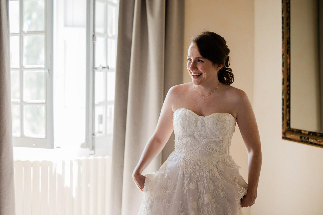 A candid moment of a bride smiling, as she prepares for the wedding ceremony.