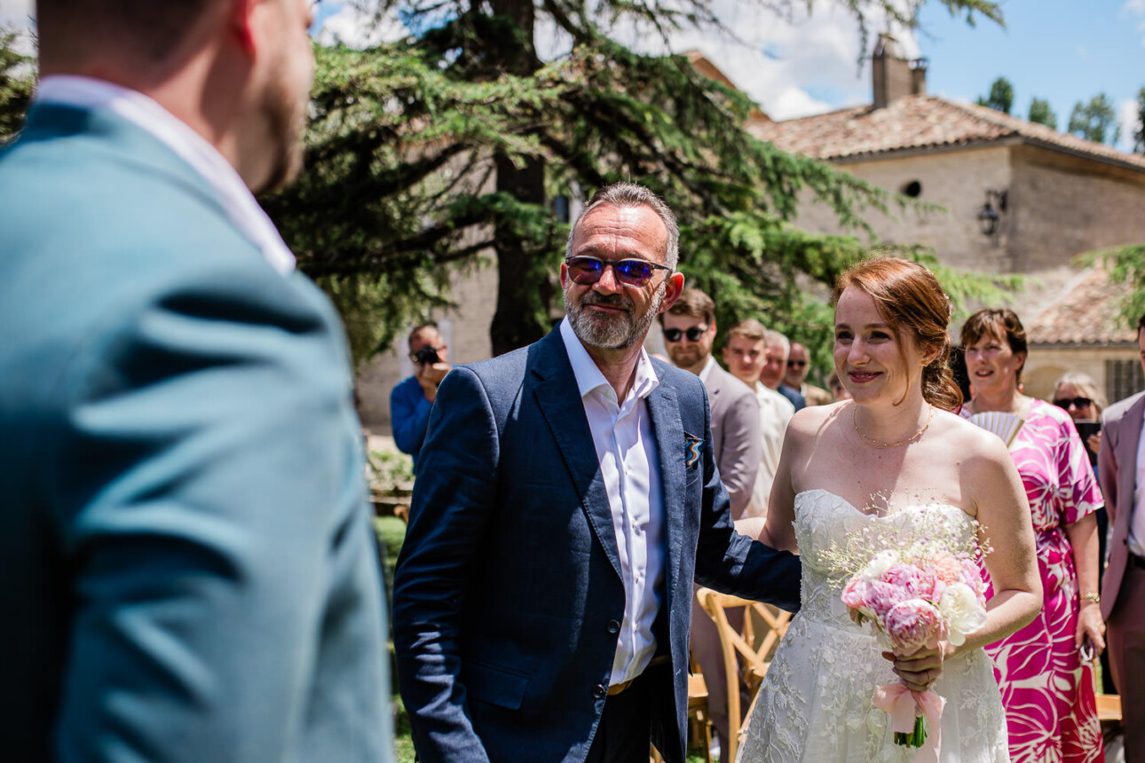 A father of the bride and his daughter walk down the aisle to meet the groom.