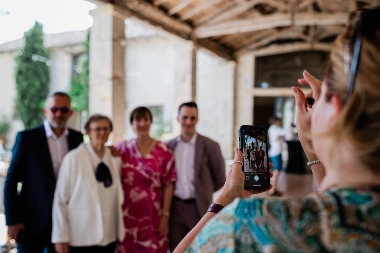 A guest takes a photo of her family, during a wedding reception.