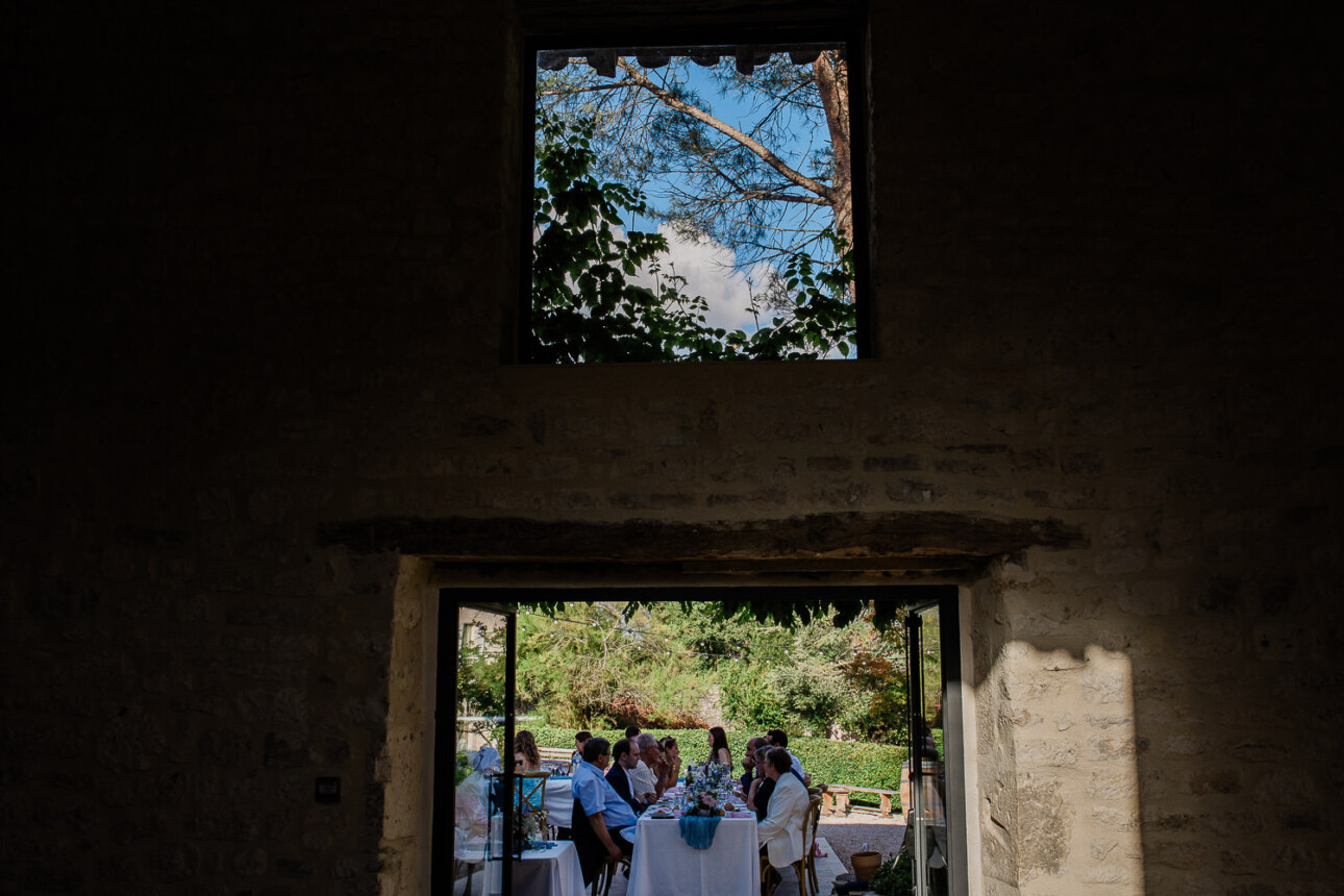 An wide angle view of guests enjoying their wedding breakfast at an outside evening reception, in the South of France.