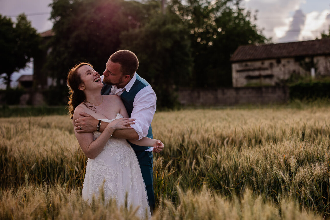 A bride and groom embrace and laugh, during a wedding portrait session for a destination wedding in the south of France.