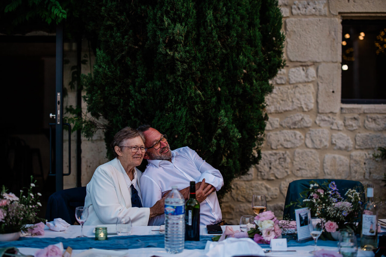 A couple lean back to enjoy the festivities of a wedding reception in Toulouse.
