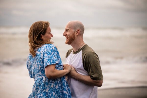 A candid moment where a woman laughs with her boyfriend, during a pre-wedding shoot by Laura Rosemary Photography
