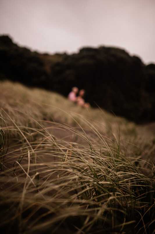 A romantic moment between a couple at Piha beach in New Zealand
