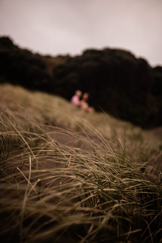 A romantic moment between a couple at Piha beach in New Zealand