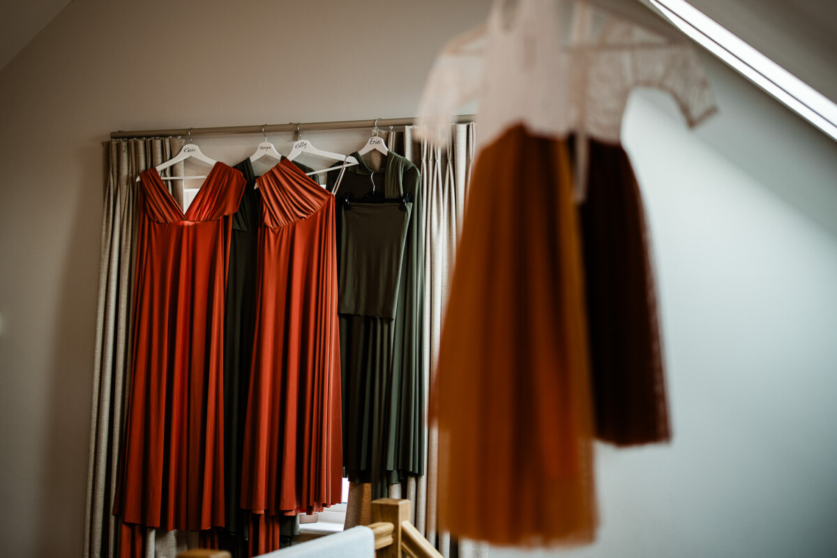 A documentary style photo of the bridesmaids' dresses, for an autumnal wedding at Polurrian on the lizard