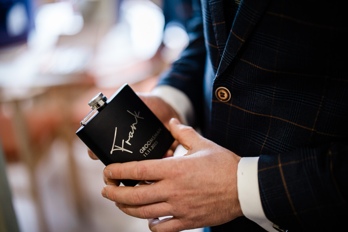A groomsman holds his wedding flask