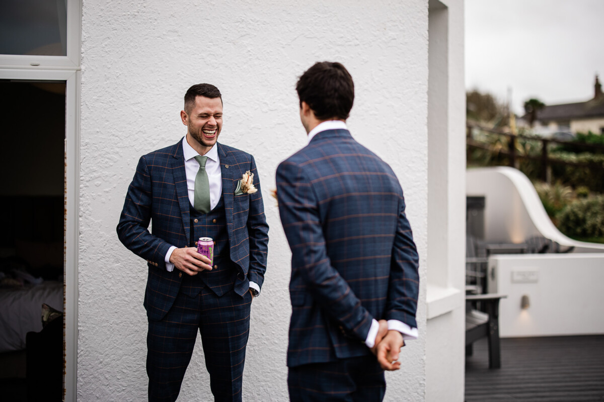 The groomsmen have a laugh during groom prep for a wedding in Cornwall