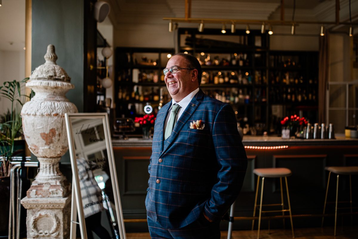 A candid image of the father of the groom smiling before the ceremony begins