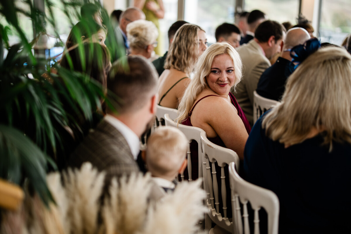A natural wedding photography capture of wedding guests chatting before the ceremony begins
