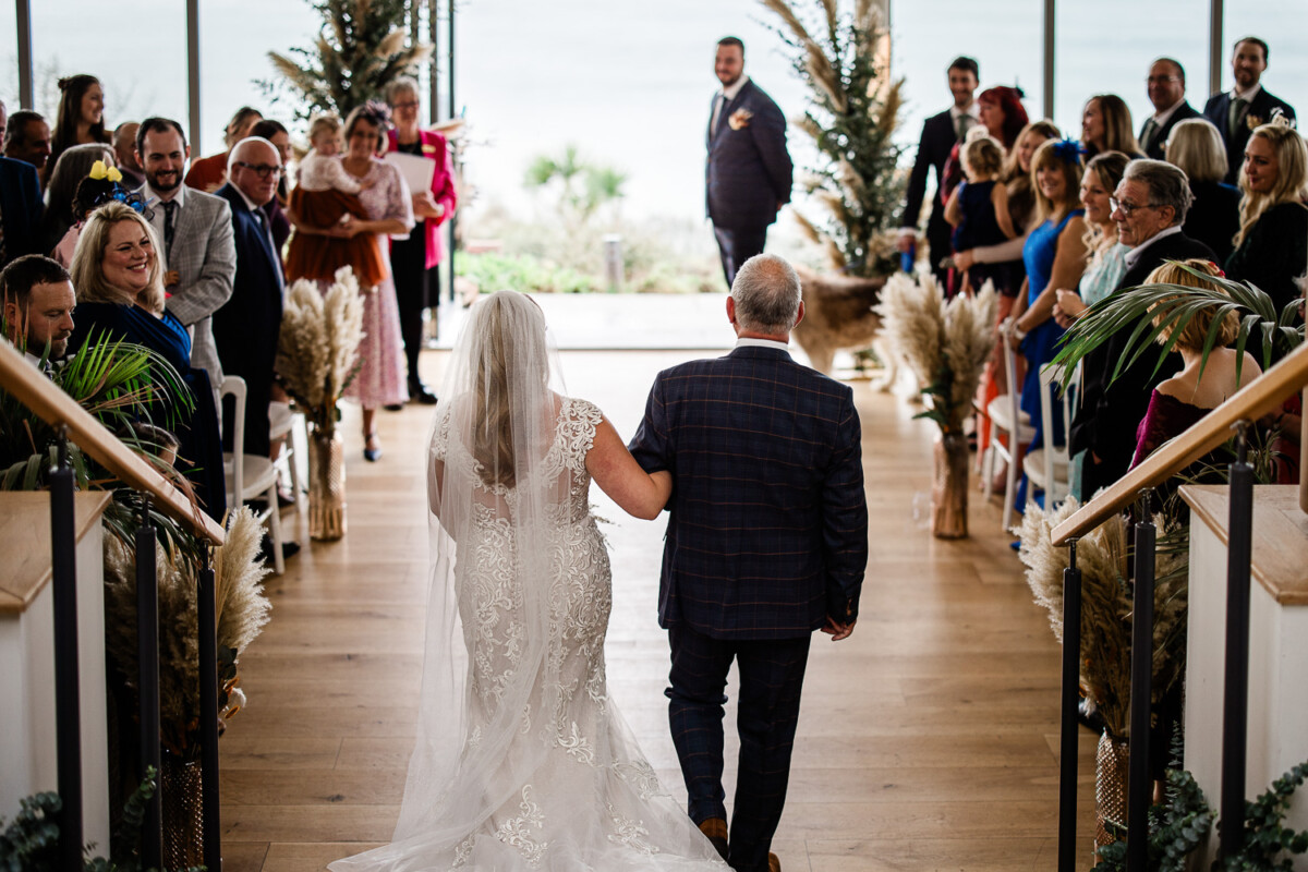 A father walks his daughter down the aisle for a wedding at Polurrian on the lizard