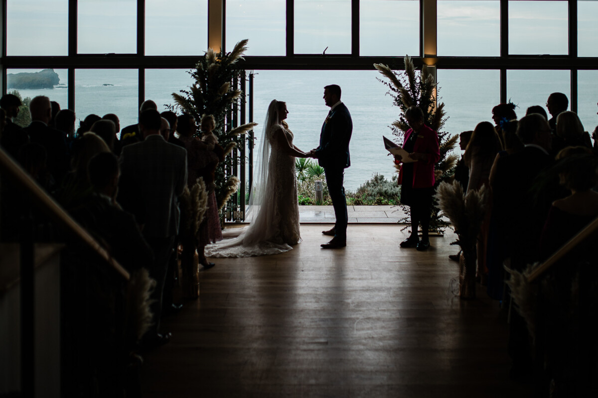 Polurrian on the lizard wedding photography of a bride and groom saying their vows with a sea view