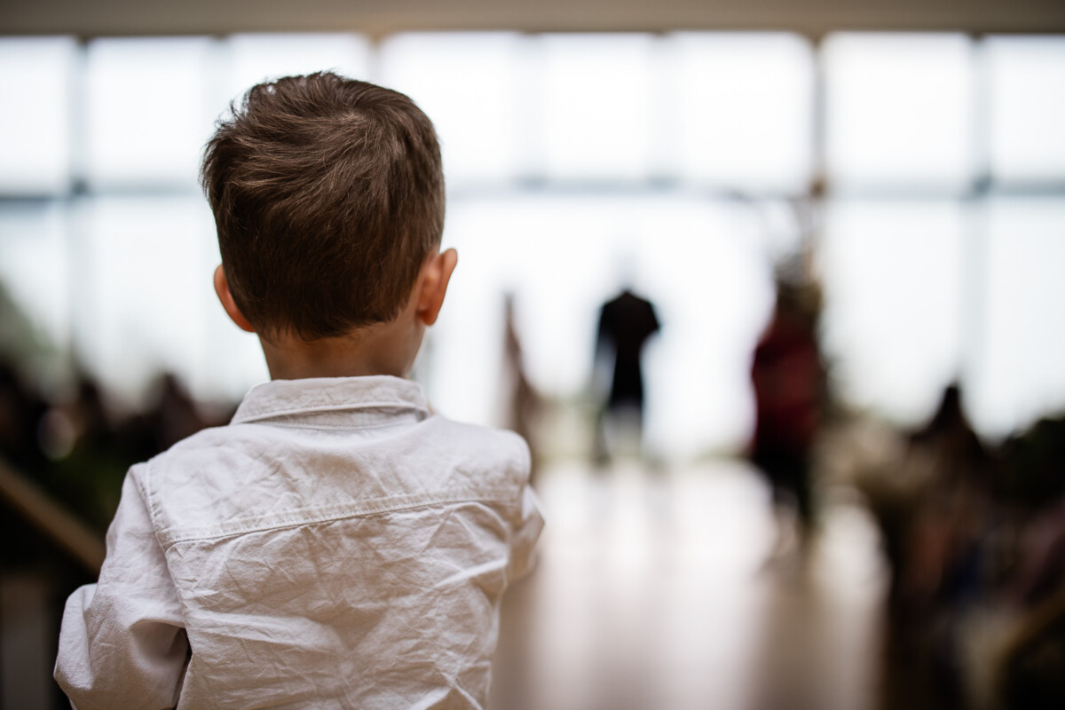 A documentary photography capture of a boy watching a wedding ceremony