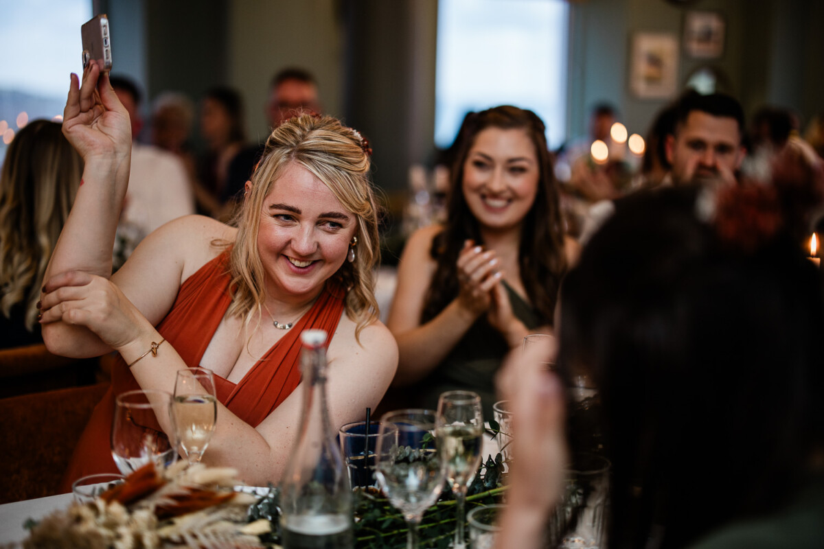A wedding guest laughs during wedding speeches at Polurrian on the lizard wedding venue in Cornwall